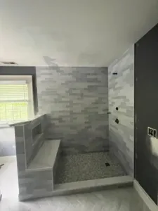 Freshly tiled walk-in shower and partially painted bathroom walls during interior painting project.