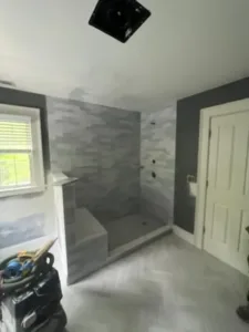 Bathroom in progress showing updated tile work and unfinished wall painting.