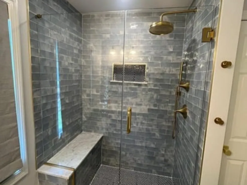 Full Bathroom Renovation featuring a modern walk-in shower with blue subway tiles, brass fixtures, a built-in bench, and elegant marble finishes—designed for comfort and timeless style.