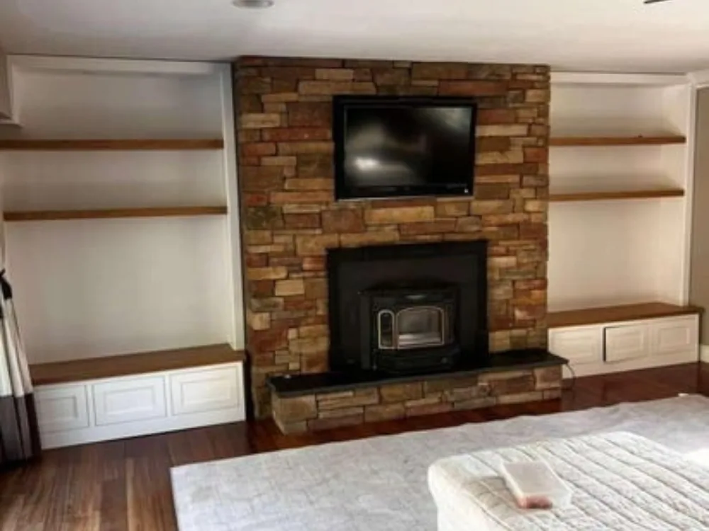 Custom built shelving surrounding a stone fireplace.